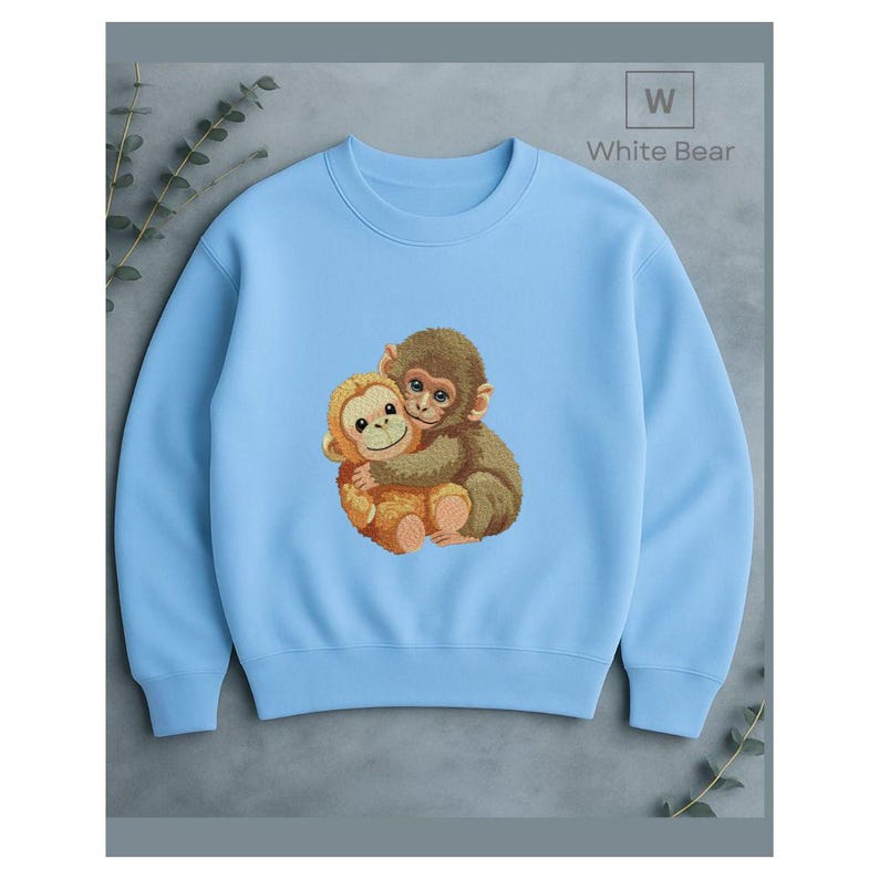 May include: A light blue sweatshirt featuring an embroidered design of two hugging monkeys. The monkeys are brown and tan, with detailed facial features. The text "White Bear" is in the upper right corner.