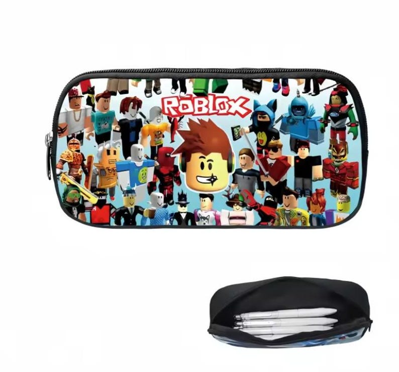 Puede incluir: Un estuche negro con un dise&ntilde;o colorido que presenta varios personajes de Roblox y el logotipo de Roblox. El estuche tiene un cierre de cremallera y un interior negro. La parte inferior de la imagen muestra el estuche abierto con bol&iacute;grafos.