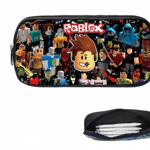 Puede incluir: Estuche negro con un dise&ntilde;o colorido con personajes de Roblox y el logotipo de Roblox. El estuche rectangular con cremallera tiene una cremallera negra. La parte inferior de la imagen muestra el interior del estuche con bol&iacute;grafos.