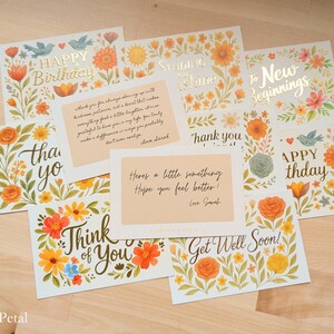 May include: A collection of rectangular greeting cards featuring floral illustrations in orange, yellow, and green. The cards display various messages including Happy Birthday, Sending You Shine, To New Beginnings, Thank You, Think of You, and Get Well Soon.