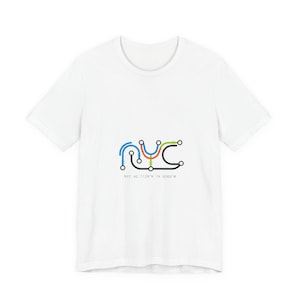 May include: White t-shirt with a colorful NYC subway map design. The graphic features the letters "NYC" in a stylized, interconnected line art style, with blue, orange, green, and black lines. Below the design is the text "NYC 40.7128°N 74.0060°W".