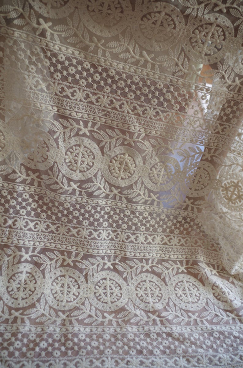 Puede incluir: Tela de encaje blanca con un delicado patr&oacute;n floral. El encaje tiene un dise&ntilde;o repetitivo de peque&ntilde;as flores y hojas, creando un aspecto delicado y femenino.