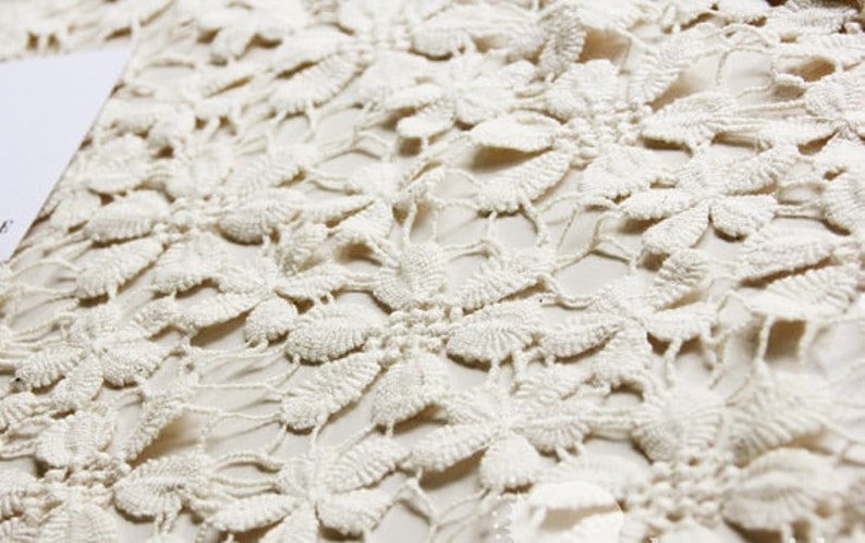 May include: White crochet fabric with a delicate floral pattern.