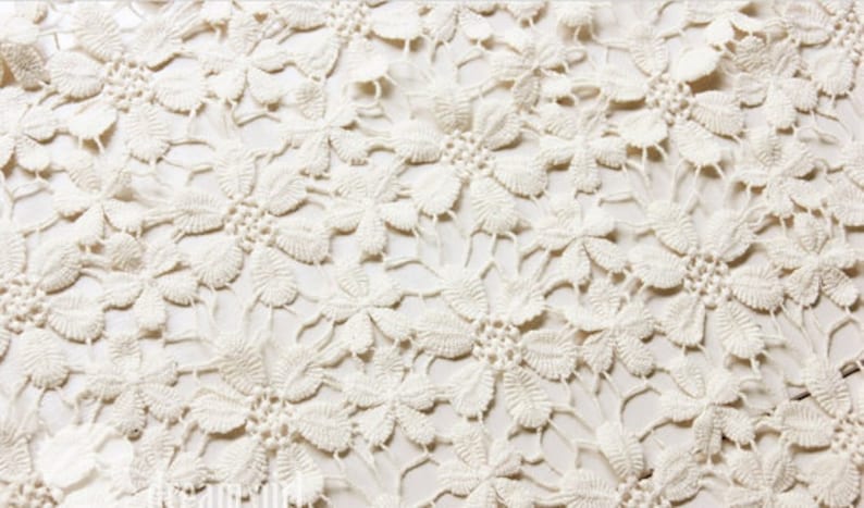 May include: White crochet fabric with a delicate floral pattern.