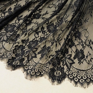 May include: Black lace fabric with a floral pattern and scalloped edge.