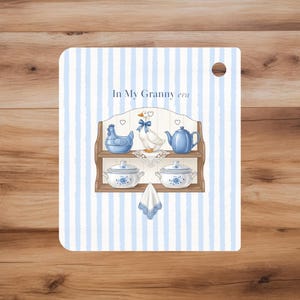 May include: A decorative card with a blue and white striped background featuring a shelf with a blue chicken, goose, and teapot. Two covered bowls and a small towel are also shown. The text "In My Granny era" is at the top.