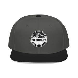 May include: A charcoal gray baseball cap with a black brim. The cap features a circular embroidered patch with a mountain range, sun, and the text "FIT FOR LIFE" in white.
