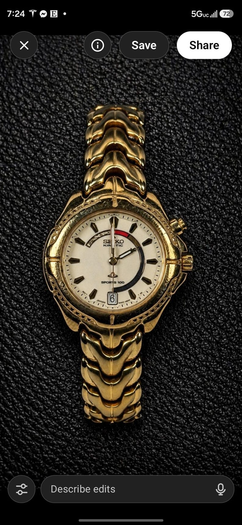May include: Gold-toned Seiko Kinetic Sports 100 wristwatch. The watch features a white dial with black and red accents, a date window, and a gold-toned bracelet. The watch is displayed on a textured black surface.