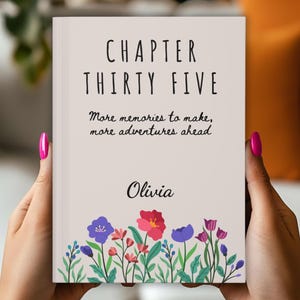 May include: A book cover with the text "CHAPTER THIRTY FIVE" and the words "More memories to make, more adventures ahead" and the name "Olivia". The cover has a floral border with red, purple, and blue flowers.