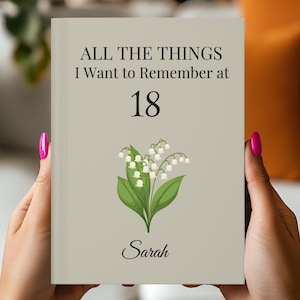 May include: A journal with the text "ALL THE THINGS I Want to Remember at 18" and the name "Sarah" below a lily of the valley illustration. The cover is a light beige color.