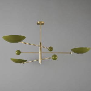 May include: A modern chandelier with a brass finish and olive green accents. The fixture features multiple arms with bowl-shaped shades and spherical details, creating a balanced and stylish design.