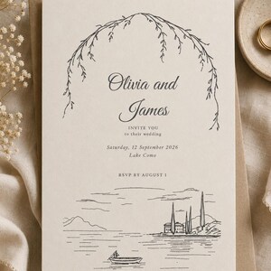 May include: A cream-colored wedding invitation card featuring a black line-art illustration of a willow arch at the top and a lakeside scene with a boat and villa at the bottom. The text reads Olivia and James, INVITE YOU to their wedding, Saturday, 12 September 2026, Lake Como, RSVP BY AUGUST 1.