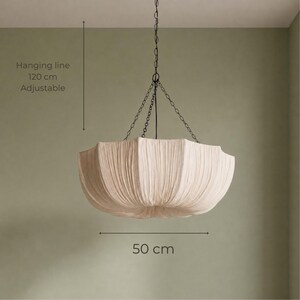 May include: A beige fabric pendant light with a pleated, bowl-shaped shade suspended by a dark metal chain. The fixture features an adjustable hanging line of 120 cm and a shade diameter of 50 cm, as indicated by the text in the image.