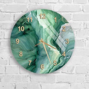 May include: Round wall clock with a green and white marbled design. The clock face features gold-colored numerals and hands, set against a swirling, abstract pattern. The clock is mounted on a white brick wall.