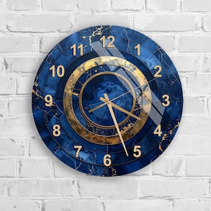 May include: Round wall clock with a blue marble design and gold accents. The clock face features gold numerals and hands, with a gold ring around the center. The clock is mounted on a white brick wall.