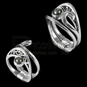 May include: Two silver rings with a black pearl in the center of each. The rings are intricately designed with swirls and curves. The rings are adjustable and can be worn on any finger.