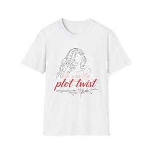 Puede incluir: Camiseta blanca con un dibujo lineal de una mujer y el texto "she was the plot twist" en escritura roja. Un diseño floral está debajo del texto. Una camiseta sencilla e informal para el uso diario.