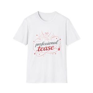 Puede incluir: Camiseta blanca con un gráfico rojo y gris. El gráfico presenta las palabras "professional tease" en una fuente estilizada, junto con una ilustración de un rostro femenino y elementos decorativos. La camiseta tiene mangas cortas y cuello redondo.