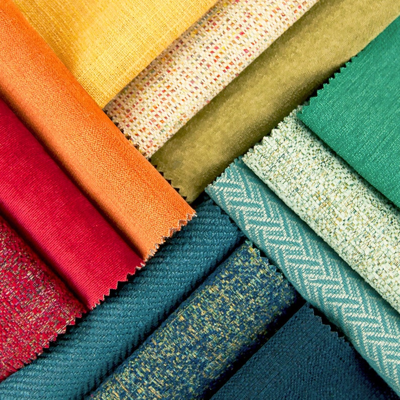 May include: A collection of fabric swatches in various colors and textures, including orange, red, green, blue, and yellow. The swatches are arranged in a fan shape, showcasing the different patterns and weaves.