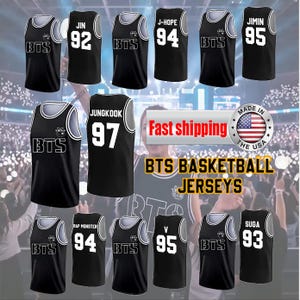 Peut inclure: Maillots de basket-ball noirs avec des bordures blanches et des noms et numéros de joueurs. Les maillots présentent le texte "BTS" et les noms "JIN", "J-HOPE", "JIMIN", "JUNGKOOK", "V" et "SUGA". L'image comprend également le texte "BTS BASKETBALL JERSEYS".