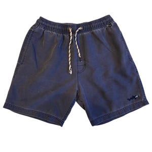 Peut inclure: Short bleu foncé avec une taille élastique et un cordon de serrage moucheté blanc et noir. Le short présente un petit logo de requin brodé sur la jambe inférieure droite et une petite étiquette noire près de la taille, au design décontracté.