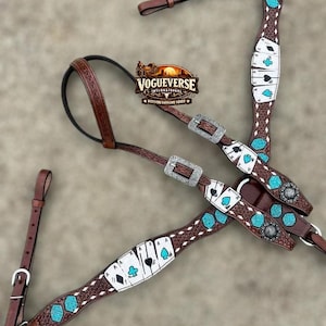May include: A brown leather horse breast collar featuring intricate basket weave tooling, silver-toned buckles, and decorative inlays of white playing cards with black and turquoise suits, alongside turquoise dice accents and circular silver conchos.