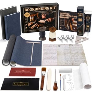 May include: A comprehensive bookbinding kit featuring a black box labeled BOOKBINDING KIT, two blank journals, rolls of blue and gray fabric, spools of thread, metal clips, a triangle ruler, glue, needles, brushes, a bone folder, and an awl.