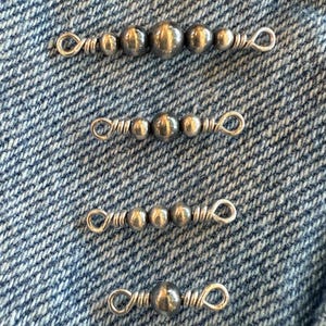 May include: Four silver-toned metal jewelry connectors arranged vertically. Each piece features a central row of polished spherical beads secured by wire-wrapped loops at both ends, creating a functional link for jewelry assembly.