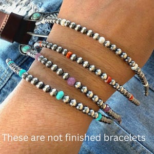 May include: Four unfinished bracelets made of small metallic silver beads interspersed with colorful accent beads in shades of turquoise, orange, white, and purple. The text "These are not finished bracelets" is printed at the bottom of the image.