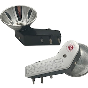 May include: Two vintage Kodak Midget Flashholders. One is black with a chrome reflector, the other is silver with a chrome reflector. Both have screw-in terminals and printed information, including "Kodak Film Lens Setting".