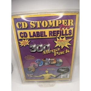 Puede incluir: Un paquete de recambios de etiquetas de CD Stomper Pro. El paquete es morado y amarillo con el texto "CD STOMPER Pro CD LABEL REFILLS" y "300 Mega Pack". El paquete contiene 150 hojas con etiquetas.