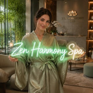 May include: A custom neon sign featuring the text Zen Harmony Spa in a glowing light green script font, mounted on a clear acrylic backing. The sign is held horizontally, displaying the illuminated lettering clearly against a spa interior.