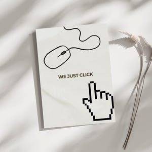 May include: A rectangular card featuring a black line drawing of a computer mouse and a pixelated hand cursor. The text "WE JUST CLICK" is printed below the mouse. The card is on a white surface.
