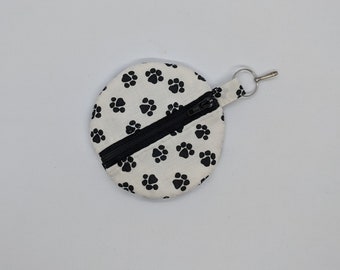 Etui pour écouteurs noir et blanc avec empreinte de patte