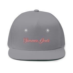 May include: A gray flat-brimmed baseball cap with the embroidered text "Summer Goals" in a cursive font. Two embroidered suns are above the text. The cap has a green underside.