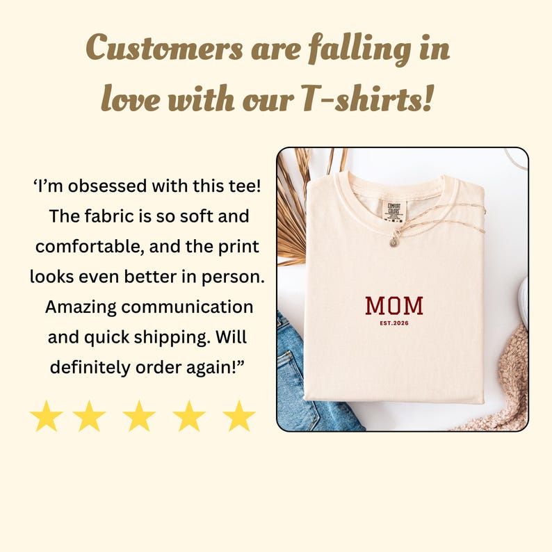 May include: Cream-colored t-shirt with the word "MOM" in burgundy, and "EST.2026" below it. The shirt is folded, with a necklace draped over it. The image includes customer reviews and the text "Customers are falling in love with our T-shirts!"