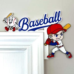 Puede incluir: Decoración de puerta con temática de béisbol con un personaje de dibujos animados de béisbol con un bate y la palabra "Béisbol" en escritura azul. También se presenta un bateador de dibujos animados con gorra y uniforme rojos.