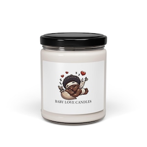 Puede incluir: Un tarro de vela blanco con tapa negra. La etiqueta presenta una ilustración de dibujos animados de un querubín durmiente con alas, corazones y el texto "BABY LOVE CANDLES". La vela está diseñada como un artículo decorativo.