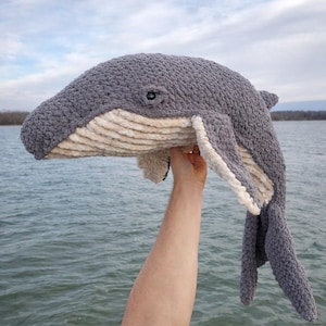 May include: A white ceramic mug with a black handle and the text "But First, Coffee" in a black, bold font. The mug is on a white surface.
