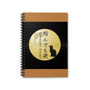 以下が含まれることがあります： 黒い表紙に金色の月、2匹の猫のシルエット、日本語のテキストが描かれたスパイラル綴じノート。 上部と下部のボーダーは温かみのある茶色です。 ノートの螺旋綴じはシルバーです。