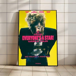 Puede incluir: Un póster enmarcado con fondo amarillo presenta a una persona con cabello claro y maquillaje. El póster tiene el texto "EVERYONE'S A STAR! WORLD TOUR" en rosa, con el nombre de la banda "5 SECONDS OF SUMMER" arriba.