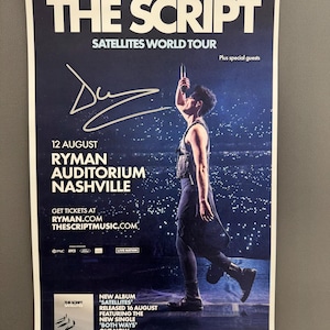 May include: Concert poster for The Script's Satellites World Tour. The poster features a dark blue background with the band's name in large white letters. It includes the date, venue, and website for tickets. A person is shown on stage holding a microphone.