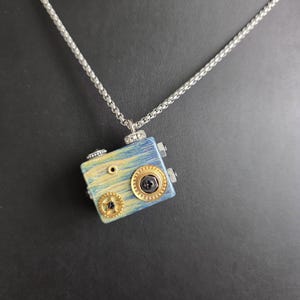 May include: A set of three ceramic mugs with a speckled, matte finish. Each mug features a different color: light blue, cream, and gray. The mugs have a simple, modern design and a comfortable handle.