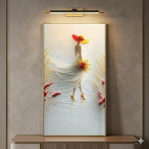 May include: A framed artwork shows a woman in a white dress and a red and yellow hat. The artwork has a textured, 3D effect, with gold accents and red and yellow floral elements. The woman is wearing yellow heels.