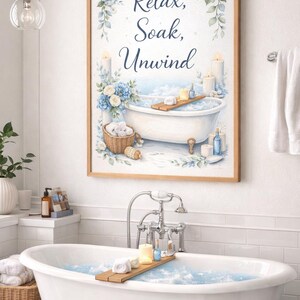 Könnte beinhalten: Ein gerahmter Aquarelldruck mit den Worten "Relax, Soak, Unwind" über einer Badewannenszene. Das Kunstwerk zeigt blaue Blumenakzente, Kerzen und ein Holztablett mit Badeprodukten. Der Text "Beautiful bathroom wall art" ist ebenfalls sichtbar.