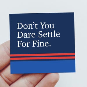 May include: A square sticker featuring a dark blue background with the white text Don't You Dare Settle For Fine. The design includes two horizontal red stripes above a solid light blue band at the bottom edge of the square sticker design.