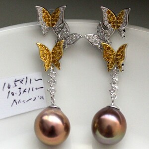 Puede incluir: Un par de pendientes colgantes con dise&ntilde;o de mariposa. Cada pendiente tiene dos mariposas con piedras amarillas y transparentes, y una perla marr&oacute;n.