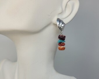 May include: Silver dangle earrings with a stack of four stones: red, turquoise, orange, and red.
