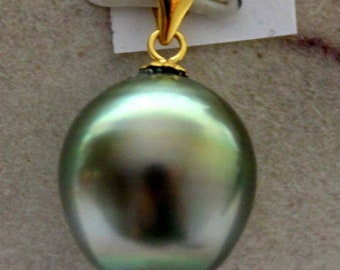 May include: A large, round, iridescent green pearl pendant with a gold-coloured bail. The pearl has a smooth, reflective surface. The bail is a simple, elegant design, and the pendant hangs from a small loop.