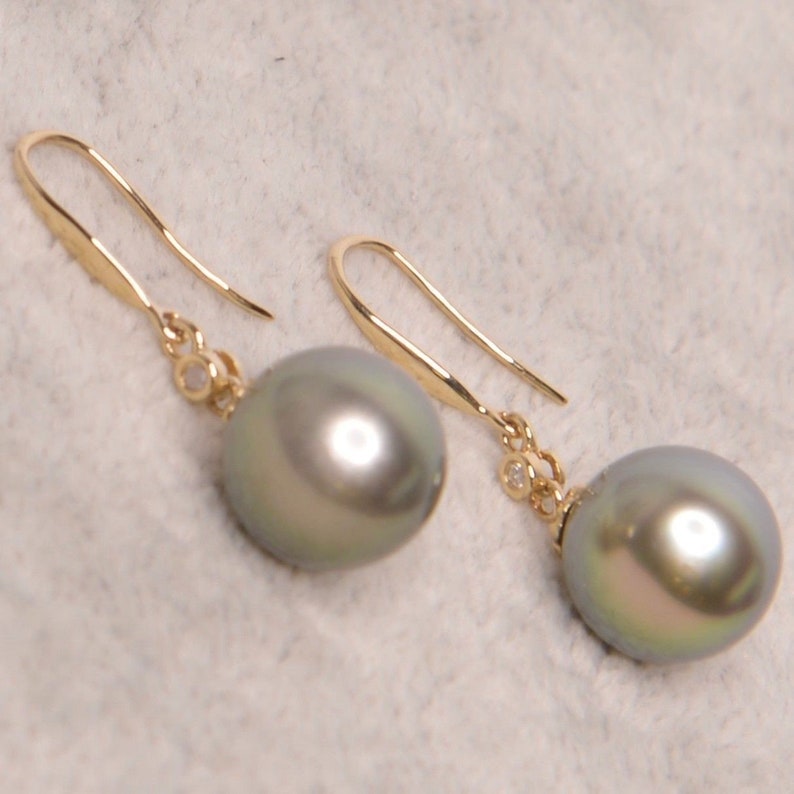 May include: A pair of gold earrings with a single gray pearl and a small diamond accent on each earring.